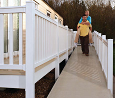 Man carrying a lady down a static caravan decking ramp