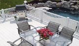 Smart Garden plastic Decking by a rockery and swimming pool with BBQ and table and chairs